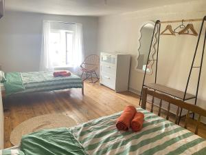 a bedroom with two beds and a dresser at Maison Basse in Malestroit