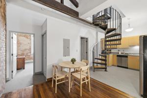 a kitchen and dining room with a table and a spiral staircase at Gorgeous downtown apartment with loft in Hartford
