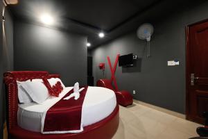 a bedroom with a bed and a red chair at Trung Mai Sân Bay T3 in Ho Chi Minh City