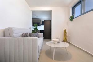 a living room with a white couch and a table at Antimo Villas - Gallini Beach House in Zakynthos +26 photos