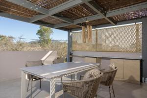 a dining room with a table and chairs on a patio at Antimo Villas - Gallini Beach House in Zakynthos