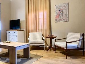 ein Wohnzimmer mit zwei Stühlen und einem Tisch in der Unterkunft Da Magy in Arborea 