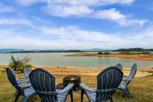 three chairs and a fire pit in front of a lake at Lakefront Mountain Oasis in Dandridge