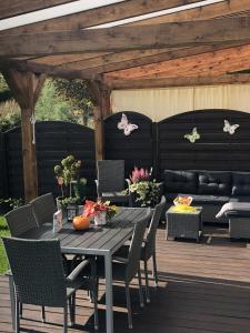 a patio with a table and chairs on a deck at Domek Polny czar in Pogorzelica