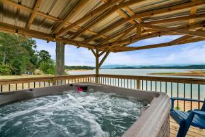 a hot tub on a deck with a view of the water at Lakefront Mountain Oasis in Dandridge
