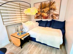 a bedroom with a bed with blue pillows and a table at Estudio Céntrico con Entrada Privada - Self Check-in HAZA ROYAL in Granada