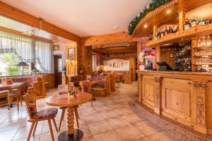 a restaurant with tables and chairs and a bar at Hotel Bellavista in Pinzolo