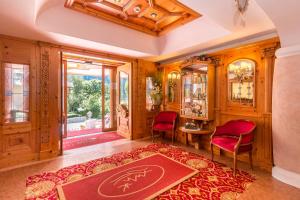 an ornate living room with red chairs and a red rug at Hotel Bellavista in Pinzolo