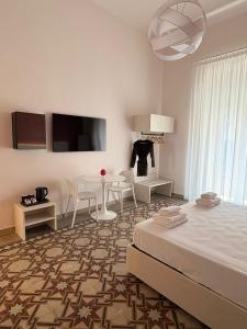 a bedroom with a bed and a table and chairs at Casa Blanca Rooms&Suites in Reggio di Calabria