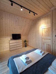 a bedroom with a bed with towels on it at Potokowe Zacisze in Zakopane