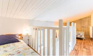 a bedroom with a bed and a white railing at Gîte in Avanton