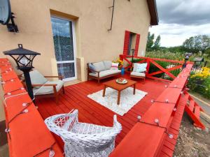 a red deck with chairs and a table on a house at Sielskie Markowskie in Markowskie