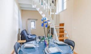 a dining room with a blue table and chairs at Gîte in Avanton