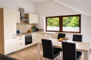 a kitchen with a wooden table and a dining room at Am Irrenbächle in Albstadt