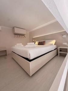 a white bedroom with a large bed with white sheets at Casa Blanca Rooms&Suites in Reggio di Calabria