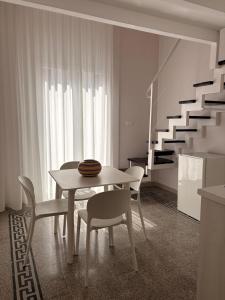 a dining room with a table and chairs and a staircase at Casa Blanca Rooms&Suites in Reggio di Calabria
