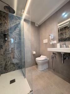 a bathroom with a shower and a toilet and a sink at Casa Blanca Rooms&Suites in Reggio di Calabria