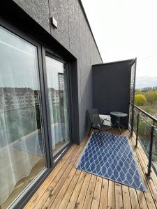 a balcony with a chair and a table on a building at Apartament Calisia II in Kalisz