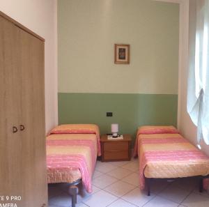 two beds in a room with green and white walls at Casa Cesa in Selargius +31 photos