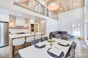 a kitchen and living room with a table and chairs at Chalet Altitude Riverfront Pet-Friendly in Saint-Raymond
