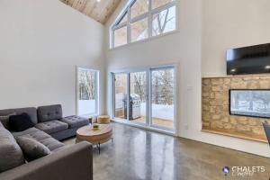 a living room with a couch and a table at Chalet Altitude Riverfront Pet-Friendly in Saint-Raymond +40 photos