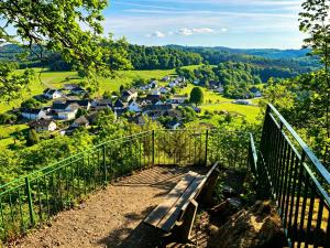 a bench sitting on a hill overlooking a village at WW Luxury Cottage in Müschenbach