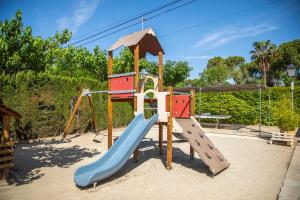 a playground with a slide in a park at Camping Clarà in Torredembarra