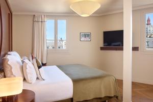 a hotel room with a bed and a tv at Hôtel d'Argenson in Paris +50 photos