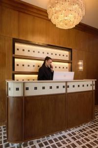a man talking on a cell phone behind a counter at Hôtel d'Argenson in Paris