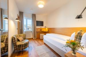 a hotel room with a bed and two chairs at Gasthof-Hotel Dannerwirt in Flintsbach