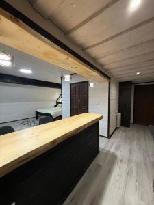 a bar in a room with wooden floors and ceilings at Садиба У Ані номер 7 in Synevyrsʼka Polyana