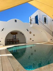 a house with a swimming pool and a staircase at Houch Ennejma, Chambres d'hotes, Spa et bien être in Al Ḩārah al Kabīrah