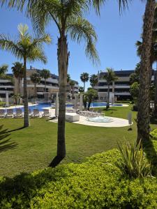 a park with palm trees and a swimming pool at Flamenca Village Apartment SALSA in Orihuela Costa