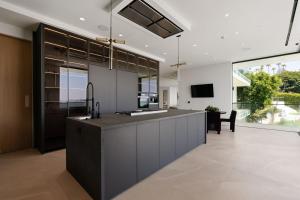 an open kitchen with a large island with a sink at Stradella Como in Beverly Glen
