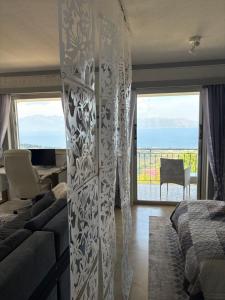 a bedroom with a bed and a couch and a view of the ocean at Villa Noza Kalamos in Kalamos