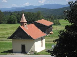 a small church with a steeple in a field at Ferienwohnung Arber in Dösingerried