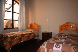 a bedroom with two beds and a window at Casa Tréveris in Sucre