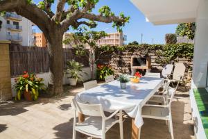 a table and chairs on a patio with a tree at Villa Paula Trinidad in Salou