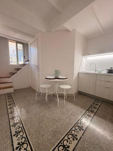 a kitchen with a table and chairs and a sink at Casa Blanca Rooms&Suites in Reggio di Calabria +29 photos
