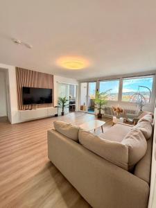 a living room with a couch and a flat screen tv at Stylish Apartment Balcony 2 BR Central in Kaiserslautern