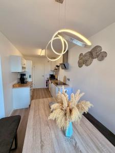 a room with a kitchen and a vase with a plant at Stylish Apartment Balcony 2 BR Central in Kaiserslautern