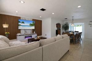 a living room with a couch and a tv on a wall at Ebenezer Home in Hallandale Beach