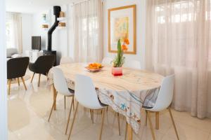a dining room with a table and white chairs at Villa Paula Trinidad in Salou