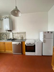 a kitchen with white appliances and a white refrigerator at Logement proche centre-ville in Bourges +3 photos