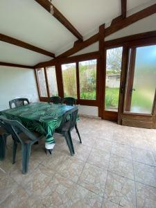 a dining room with a table and chairs and windows at Logement proche centre-ville in Bourges