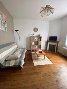 a bedroom with a bed and a table and a fireplace at Logement proche centre-ville in Bourges