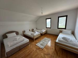 a room with two beds and a couch and two windows at Highland guest house Vuthaj in Vusanje