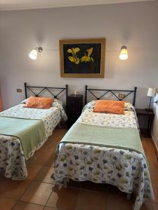 a bedroom with two beds and a painting on the wall at El Olivo de Sansol in Sansol