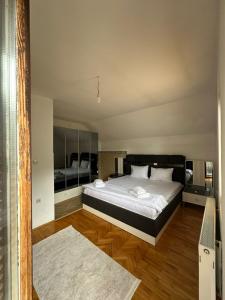 a bedroom with a large bed and wooden floors at Highland guest house Vuthaj in Vusanje