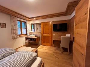 a bedroom with two beds and a flat screen tv at Biobauernhof Windbachgut in Eben im Pongau